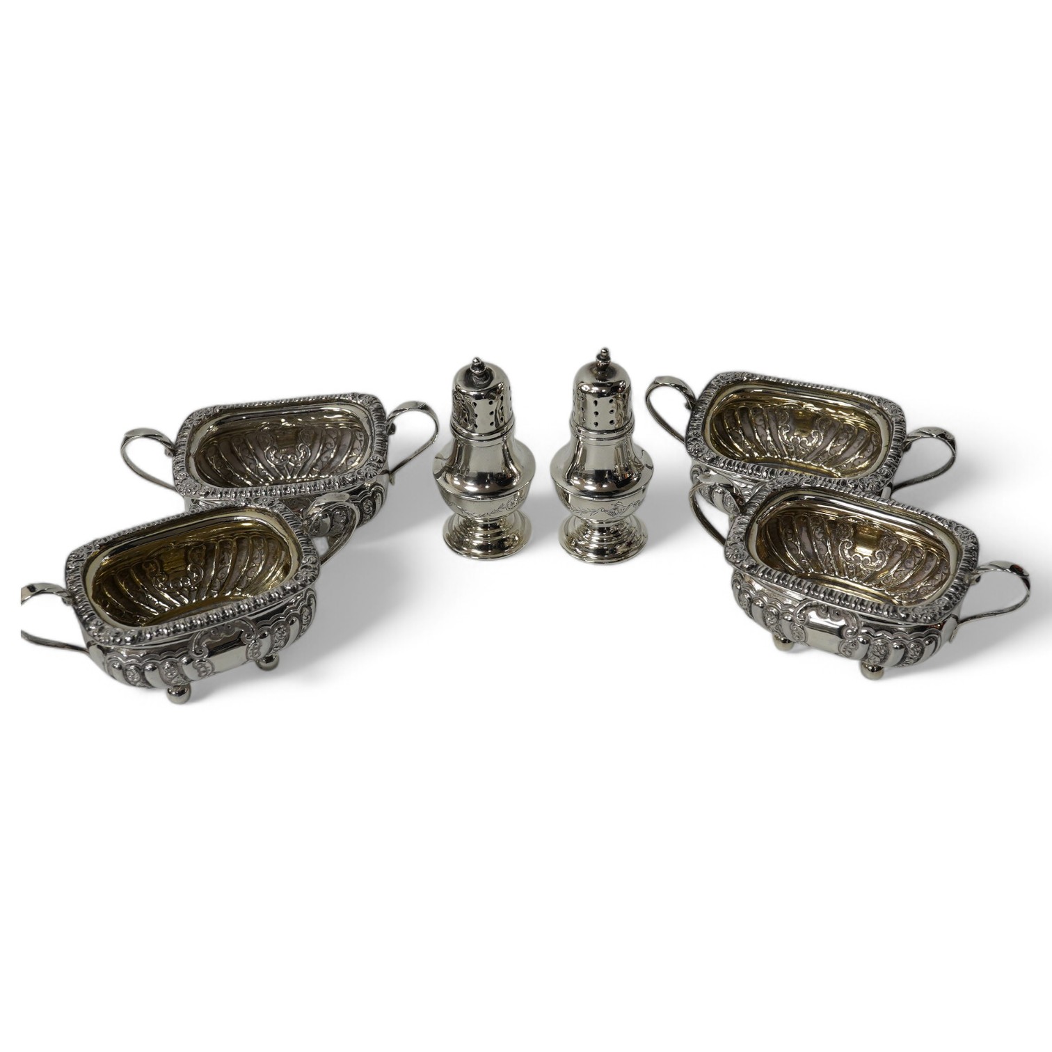 A set of four late Victorian embossed silver two handled salts, Birmingham, 1896, 98mm and a pair of silver peppers. Condition - fair to good